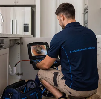 Clearing a blocked sink at a Chifley property